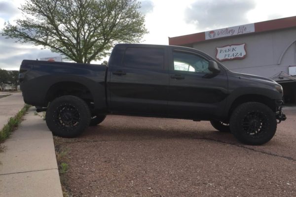 Black pickup truck with ProCote liner along wheel wells and rocker panel